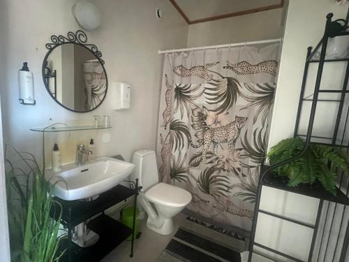 a bathroom with a shower curtain with a toilet and a sink at Spa For Hjo in Hjo