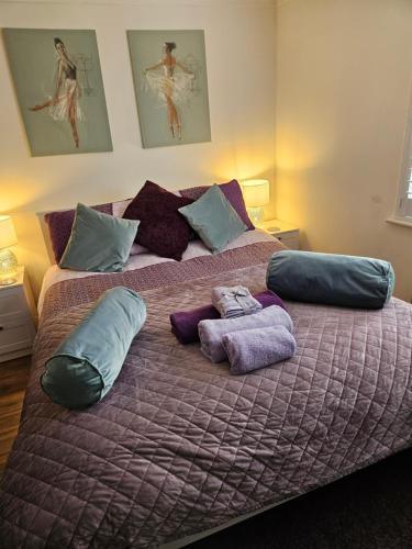 a large bed with pillows and towels on it at Siobhan's abode 3 Deluxe doubles and 1 king size NO PETS in Swindon