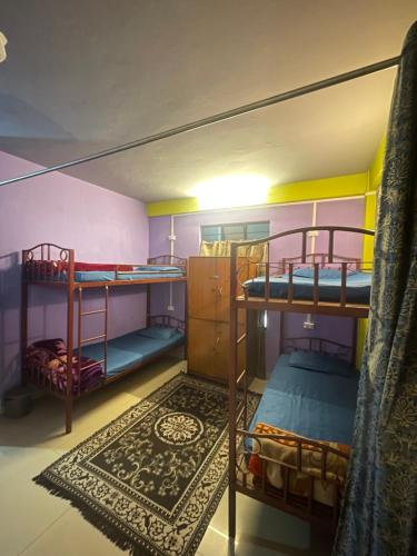 a room with two bunk beds and a rug at Hazz Backpackers Hostel in Shillong