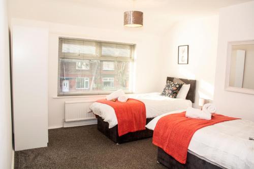 a bedroom with two beds and a window at 3 Bed - Shefa Homes in Manchester