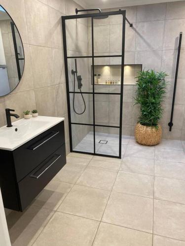 a bathroom with a shower and a sink and a mirror at Workers Stay - Temporary House Stockholm in Rönninge