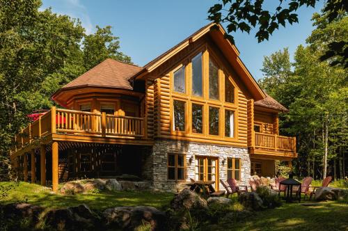 a log cabin with a wrap around deck at Fiddler Lake Resort - Deer 76 in Mille-Isles