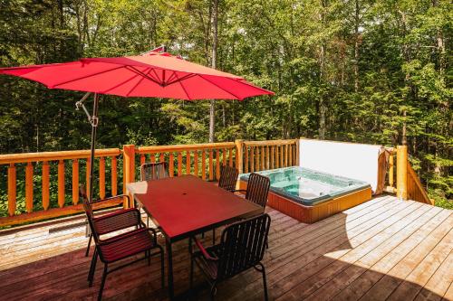 a wooden deck with a table and an umbrella at Fiddler Lake Resort - Deer 76 in Mille-Isles
