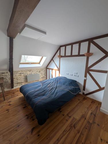a bedroom with a large bed in a attic at Gîte des Gatinelles in Erbray