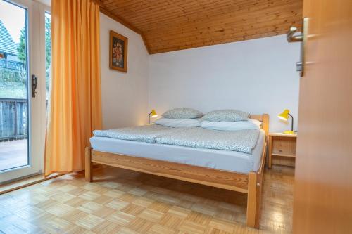 a bedroom with a bed and a large window at Apartments and rooms Pri Urhu in Bohinj