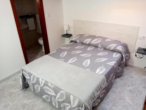a bedroom with a bed with a gray and white comforter at Rías Baixas in Villanueva de Arosa