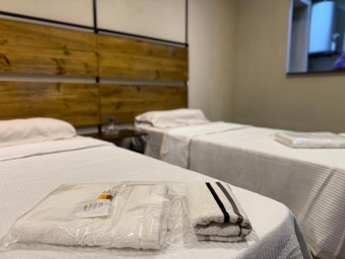 a room with two beds with white sheets at Casita de Ceci in Pilar