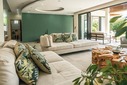 a living room with two couches and a table at Sublima Villa, Luxe et élégance in La Gaulette