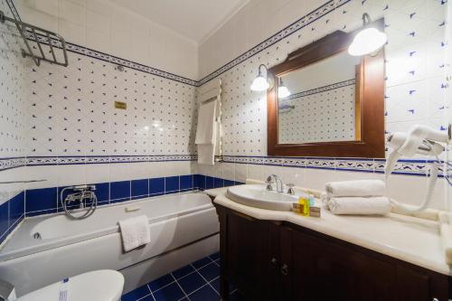 a bathroom with a tub and a sink and a bath tub at Mom Hotel Buyukada in Adalar