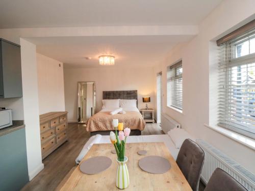 a bedroom with a bed and a table with flowers on it at Toote Suite in Yarm