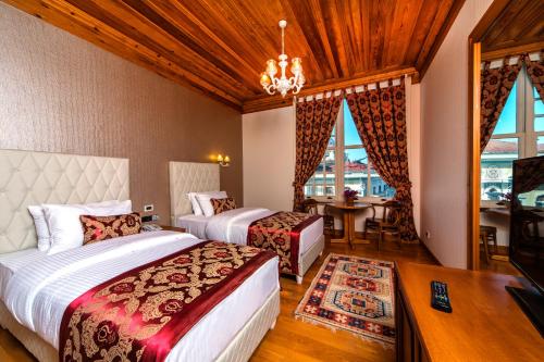 a bedroom with two beds and a chandelier at Mom Hotel Buyukada in Adalar