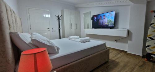 a bedroom with a bed and a television on a wall at House Elbasan city center 3 in Elbasan