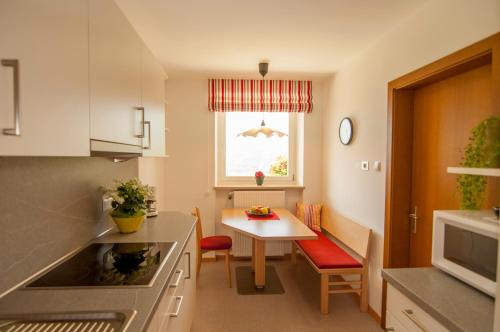 a kitchen with a table and a small table and a window at Klostergut in Castelbello-ciardes