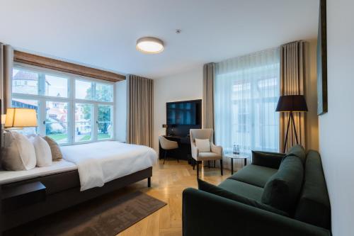 a bedroom with a bed and a couch and a desk at Nunne Boutique Hotel in Tallinn