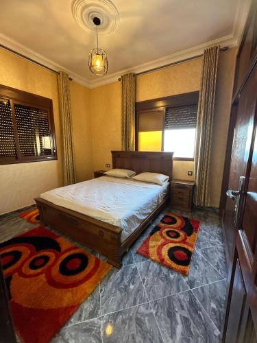 a bedroom with a bed and a rug on the floor at ZAHA Appart in Ksar es Sghir