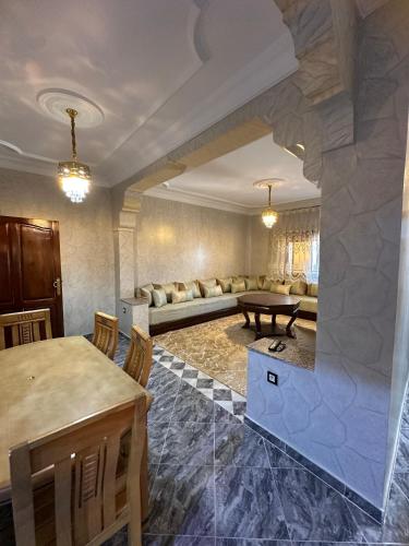 a living room with a couch and a table at ZAHA Appart in Ksar es Sghir
