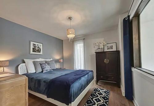a bedroom with a blue bed and a window at Lakeside Lodge at Tremblant in Brébeuf