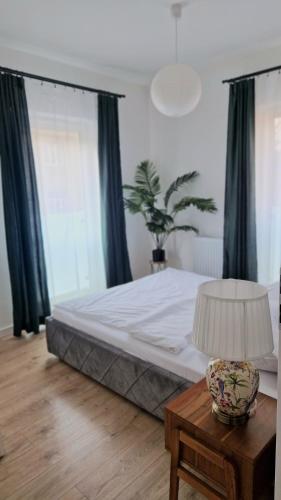 a bedroom with a bed and a table with a lamp at Apartament Bellissima in Bielsko-Biała