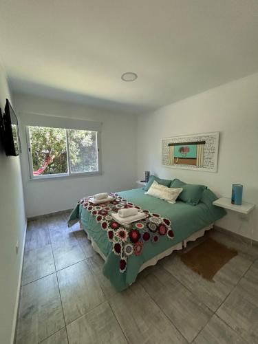 a bedroom with a bed with a green comforter at Casa Boutique de la Sierra in Sierra de los Padres