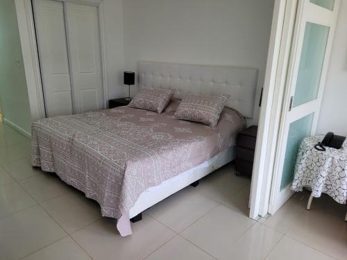a bedroom with a bed and a mirror at Green Park Solanas Monoambiente Punta del Este in Punta del Este