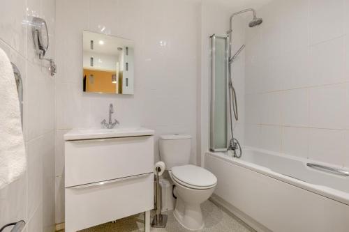 a bathroom with a toilet and a sink and a tub at 2 Bed in Reedham oc-c29528 in Haddiscoe