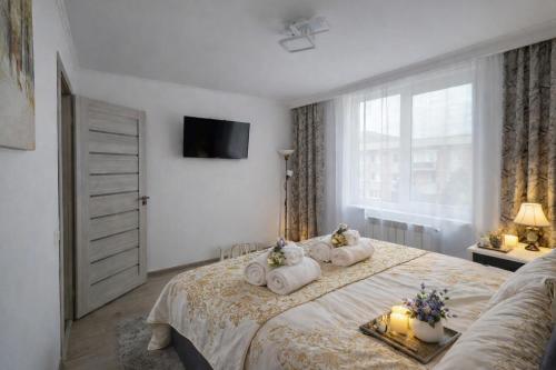 a bedroom with a large bed with candles and a window at Delux Flat Straja in Lupeni