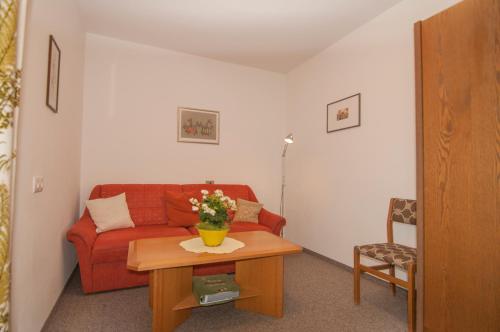 a living room with a red couch and a table at Klostergut in Castelbello-ciardes