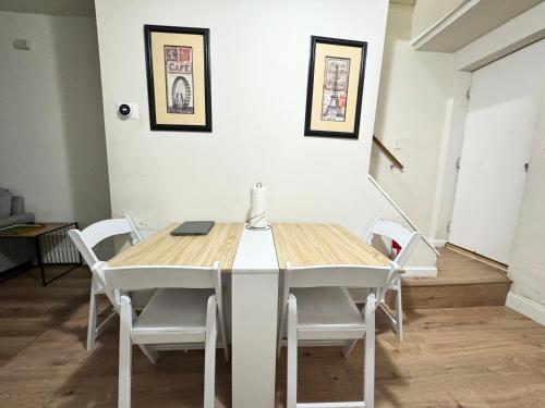 a dining room table with white chairs and a laptop on it at Downtown Private Rooms - Close to M&T, Orioles, Topgolf, Horseshoe Casino in Baltimore