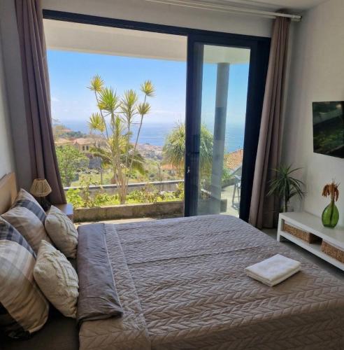 a bedroom with a bed and a large window at CoLiving Funchal in Funchal