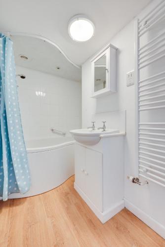 a white bathroom with a sink and a bath tub at 3 Bed in Westleton oc-swc in Westleton
