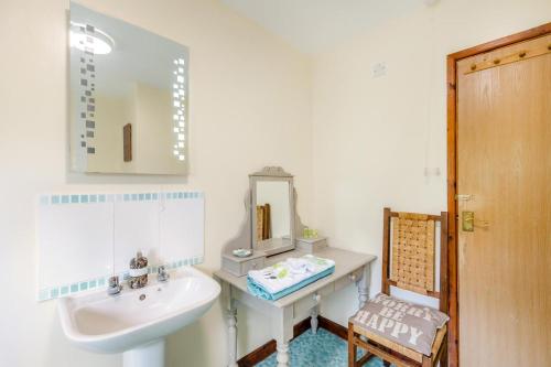 a bathroom with a sink and a mirror at 4 Bed in Tywyn oc-23385 in Llanfihangel-y-Pennant