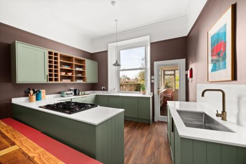 a kitchen with green cabinets and a white counter top at 6 Howard Place in St. Andrews