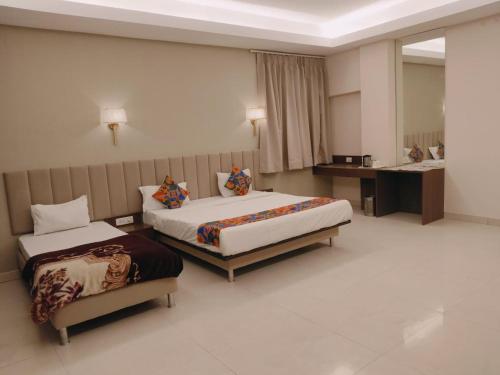 a hotel room with two beds and a desk at TTAMAASHA INNN in Chinhat