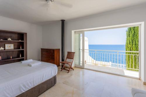 a bedroom with a bed and a large window with the ocean at Villa Acantilado Cabo de Palos in Cabo de Palos