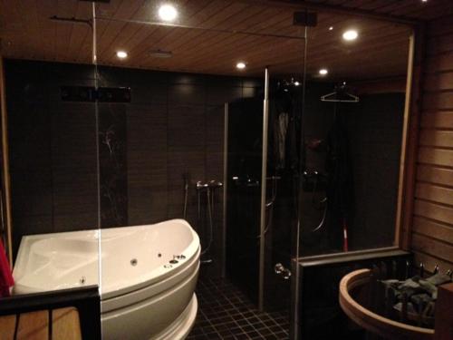 a bathroom with a tub and a shower and a toilet at Runoilevi B3 Visit Levi in Sirkka