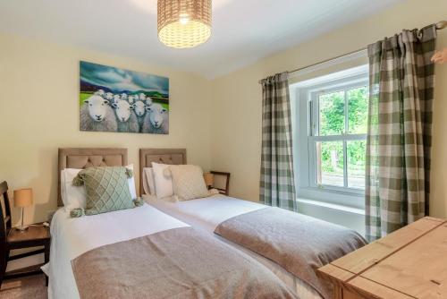 a bedroom with two beds and a window at 2 Bed in Staffield oc-j32453 in Kirkoswald