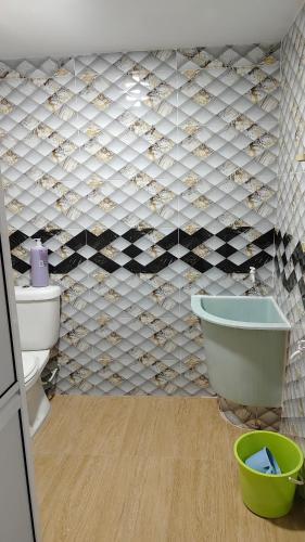 a bathroom with a toilet and a bath tub at Seetha's Homestay in Lunas