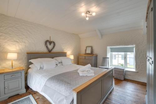 a bedroom with a large bed with white sheets at 2 Bed in Llanmadoc oc-hh469 in Llanmadoc
