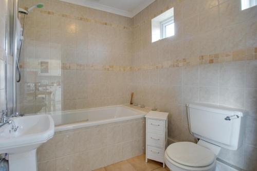 a bathroom with a tub and a toilet and a sink at 2 Bed in Llanmadoc oc-hh469 in Llanmadoc