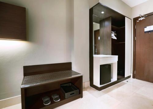 La salle de bains est pourvue de toilettes, d'un lavabo et d'un miroir. dans l'établissement Hotel Neo+ Balikpapan by ASTON, à Balikpapan