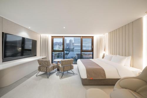 a hotel room with a bed and a large window at Daegu Hyeonpung Prana Hotel in Daegu