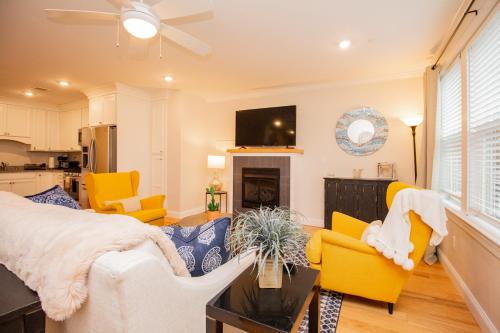 a living room with yellow chairs and a tv at 2 Bedroom Unit w Elevator & In-Unit Laundry in Boston
