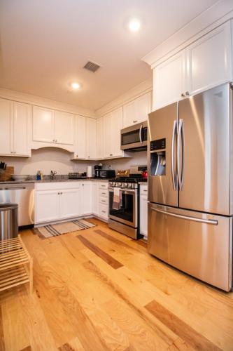 a kitchen with white cabinets and a stainless steel refrigerator at 2 Bedroom Unit w Elevator & In-Unit Laundry in Boston