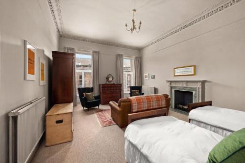 a bedroom with two beds and a fireplace at 6 Howard Place in St. Andrews