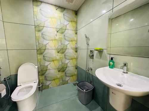 a bathroom with a toilet and a sink and a shower at Hestia Homestay- 2 Bedroom Retreat Aymanam in Kottayam