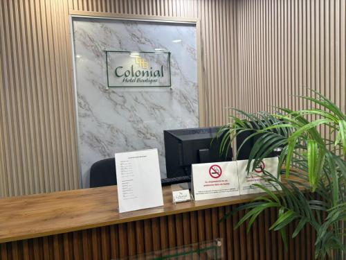 a reception desk with a computer on a marble wall at Colonial Hotel Boutique by VBermor in Santo Domingo