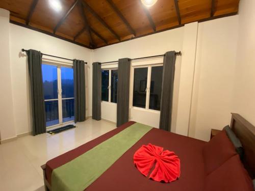 a bedroom with a large bed and large windows at mountain retreat villa in Kandy