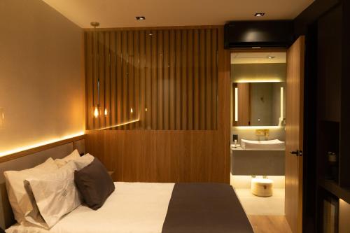 a bedroom with a bed and a bathroom with a sink at Punto Suites Periférico Sur in Mexico City