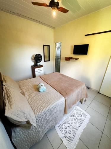 a bedroom with a bed and a ceiling fan at Casinha Charmosa in Miguel Pereira