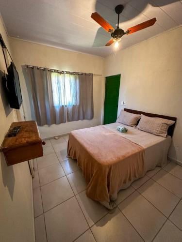 a bedroom with a bed and a ceiling fan at Casinha Charmosa in Miguel Pereira